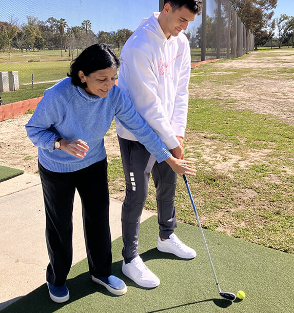 kiran kanwar teaching golf on a student